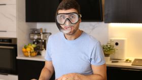 Imagen de un hombre cortando cebolla con gafas de buceo