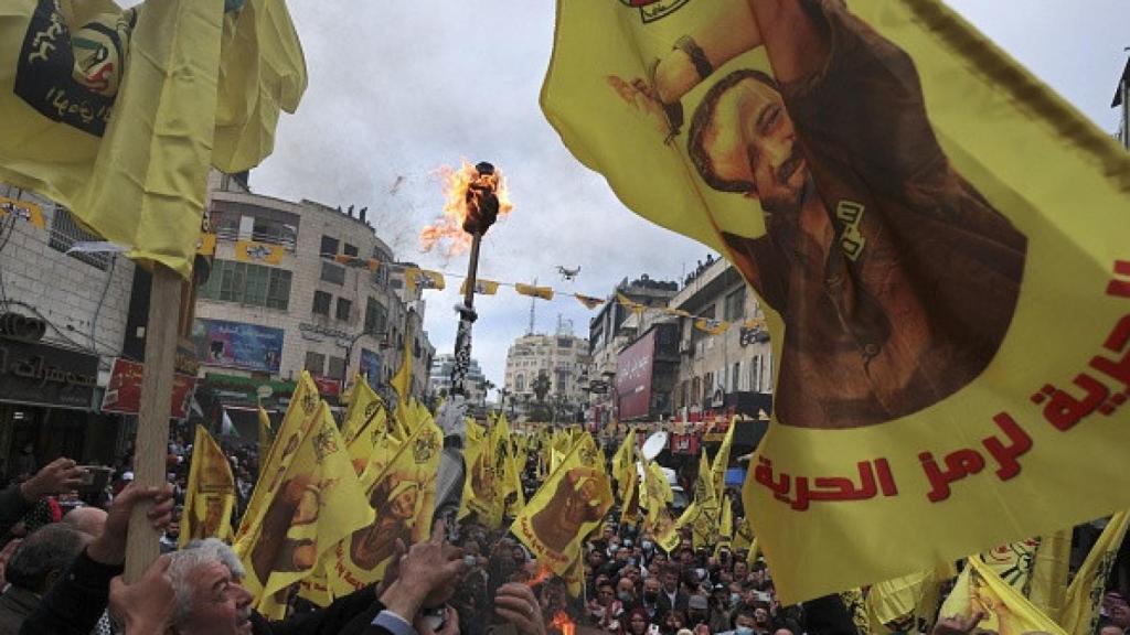 Palestinos ondean pancartas con la imagen del líder encarcelado de Fatah, Marwan Barghuti,  en diciembre de 2021.