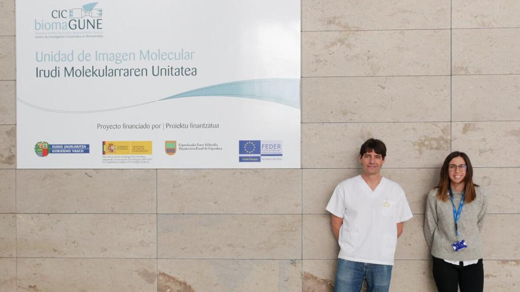 Izqu: Jordi Llop. Der: Cristima Simó, ambos delante de la Unidad de Imagen Molecular del biomaGUNE.