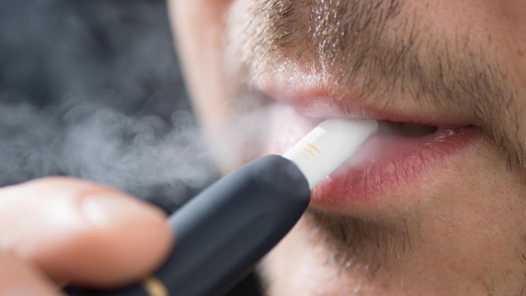 Un hombre consume un dispositivo de tabaco calentado.