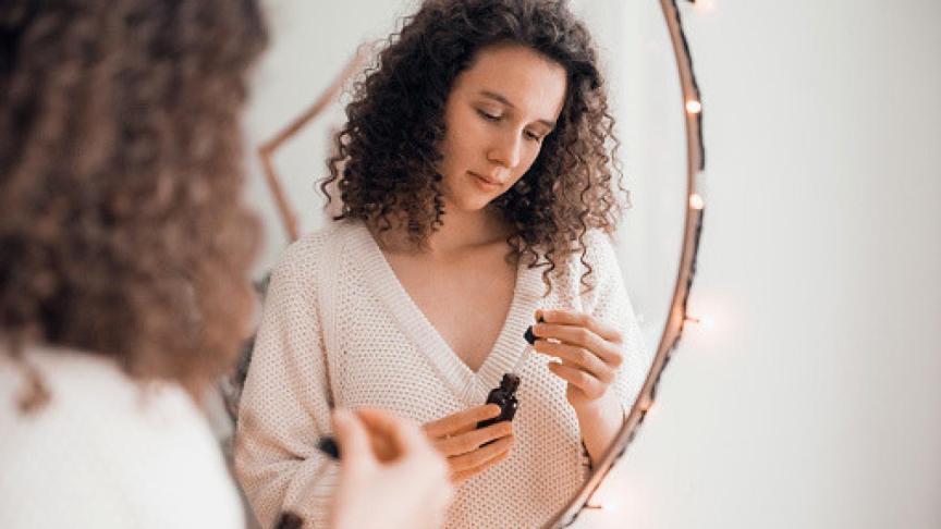 Una mujer aplicándose sérum para la piel.