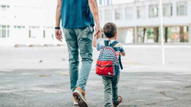 Un padre llevando a su hijo al colegio