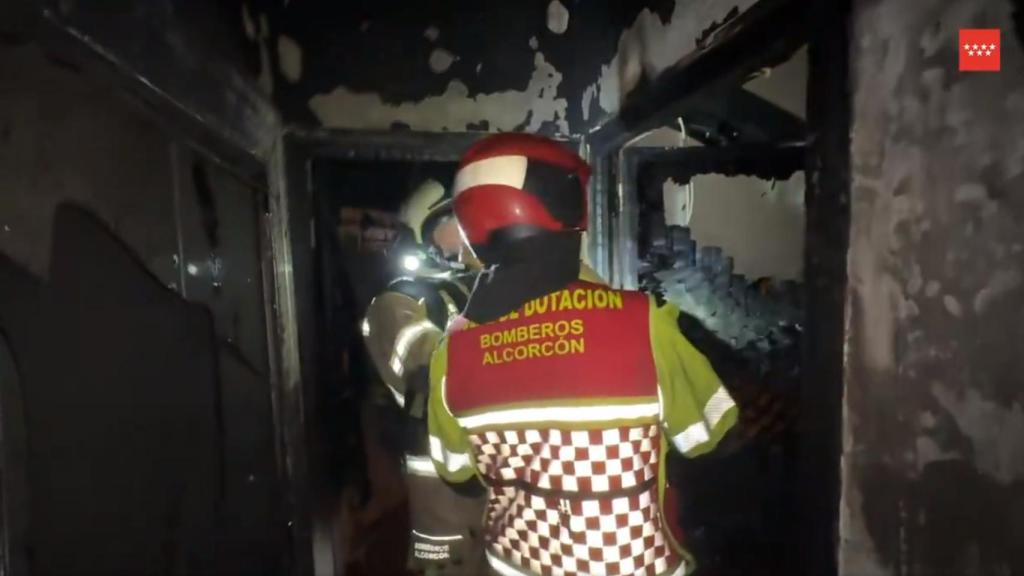 Bomberos en el interior de la vivienda incendiada.