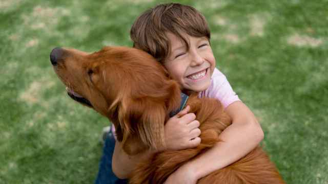 Imagen de un niño abrazando a un perro