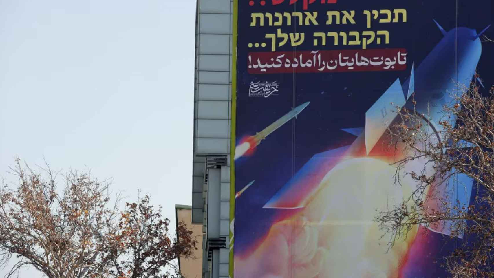 Una valla que muestra misiles iraníes un edificio en la plaza Palestina de Teherán.