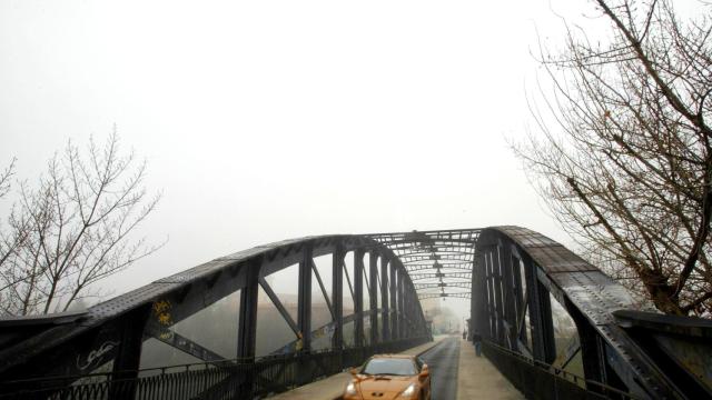 Un coche circulando por el Puente Colgante de Valladolid