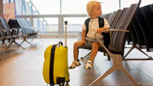 Imagen de archivo de un niño con una maleta.