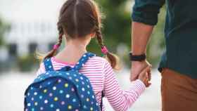 Una niña va al colegio con su padre.