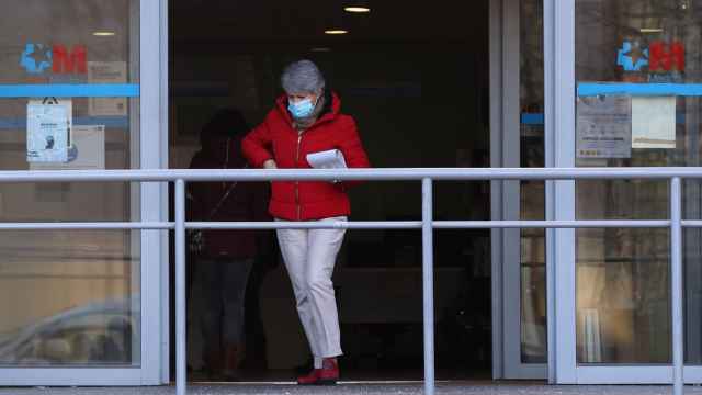 Una mujer con mascarilla sale de un centro de salud en Madrid.