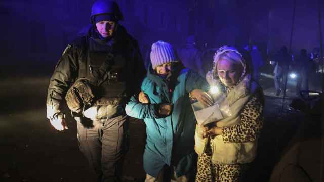 Un policía ayuda a dos mujeres tras un bombardeo ruso en Kharkiv, Ucrania.