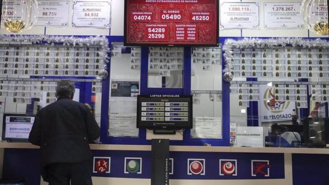 Un hombre comprando décimos de lotería.