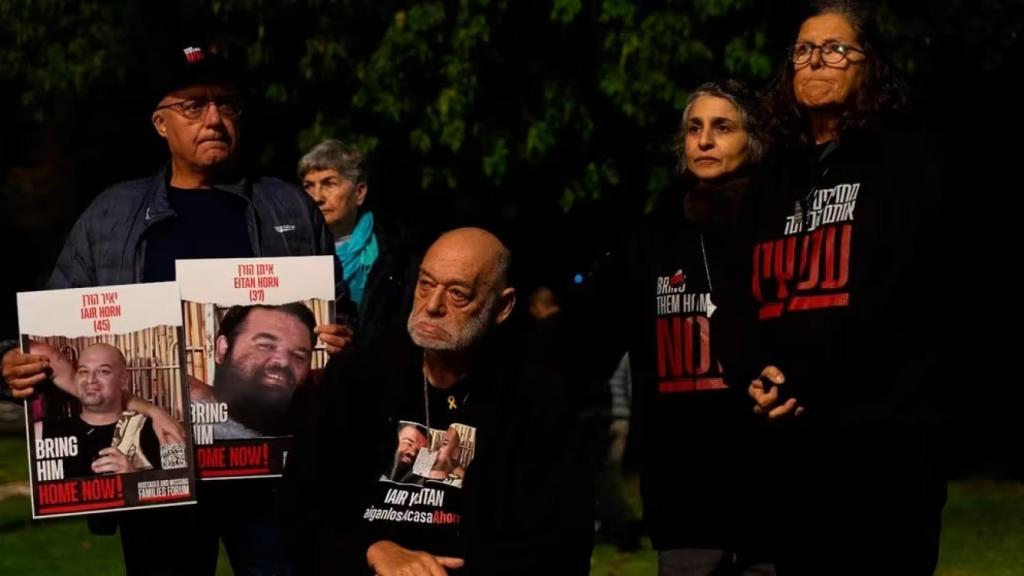 Itzik Horn, acompañado de seres queridos y las fotografías de sus hijos secuestrados por Hamás.