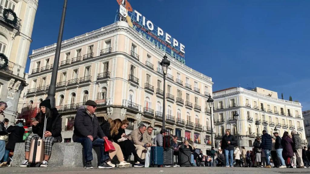 Varios ciudadanos sentados sobre los nuevos bancos de la Puerta del Sol.