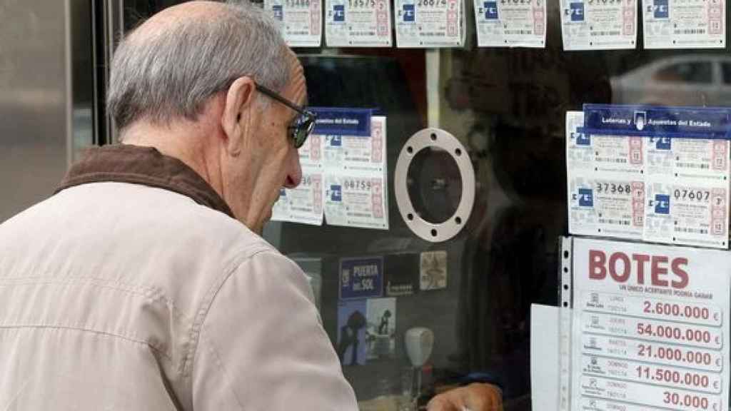 Un hombre comprando décimos de lotería.
