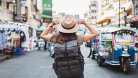 Mujer de espaldas viajando de mochilera.