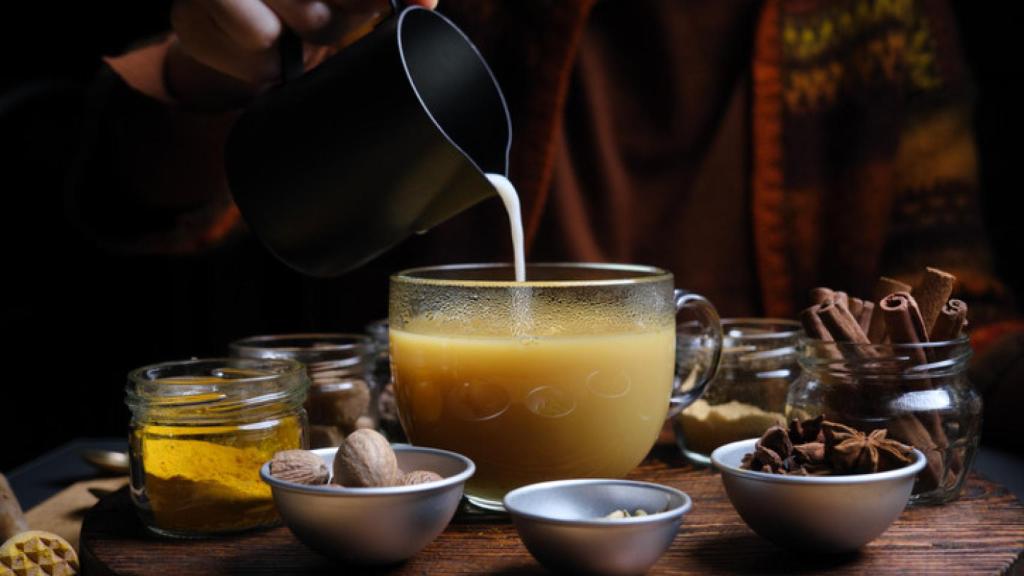 Una taza de 'chai latte' junto a las especias que contiene.