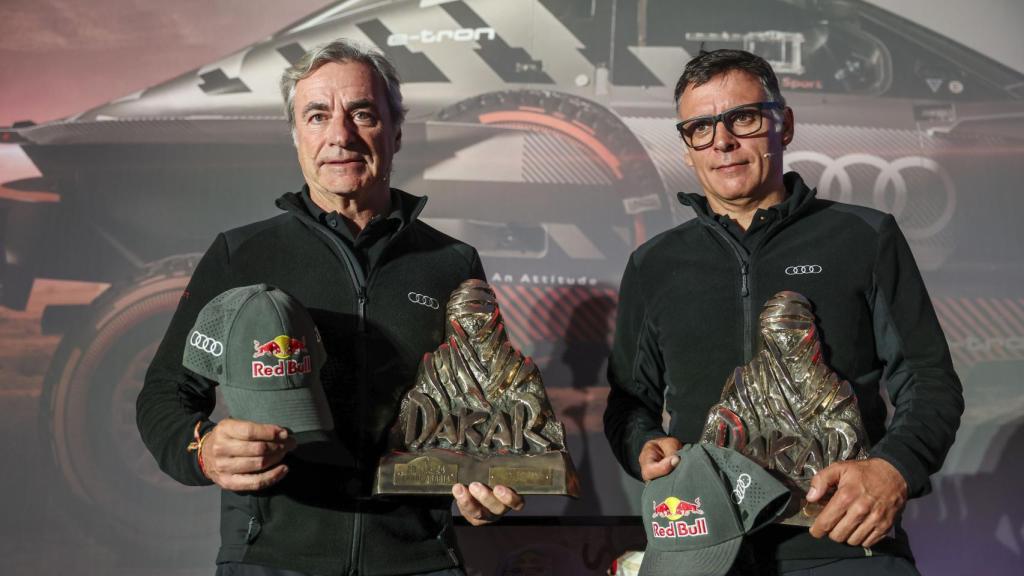 El piloto español Carlos Sainz (Audi) (i) junto a su copiloto Lucas Cruz comparecen ante la prensa tras llegar este sábado a Madrid.