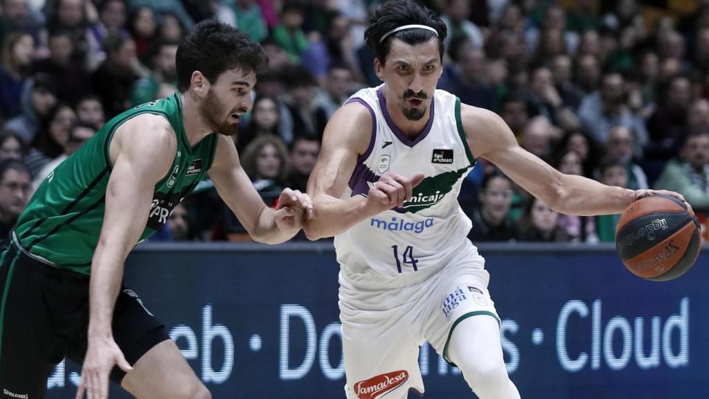 Dedovic (d), alero del Unicaja de Málaga, intenta avanzar ante la presencia de Busquets.