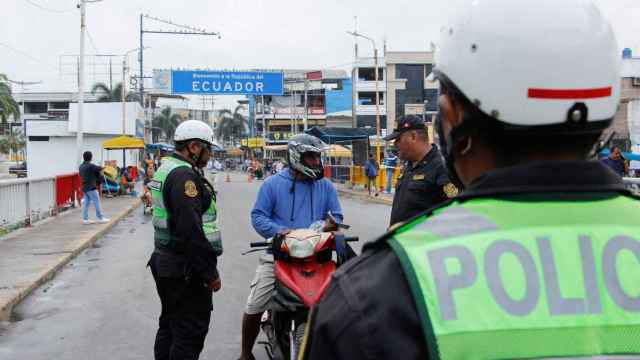 Dos agentes de policía peruanos hablan con un hombre procedente de Ecuador.