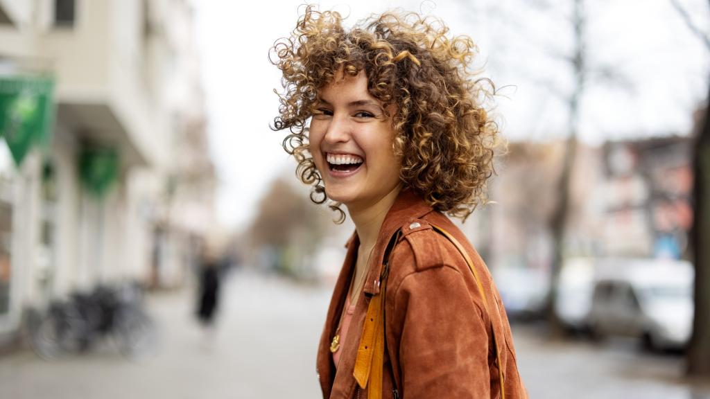 Mujer feliz paseando por la calle.