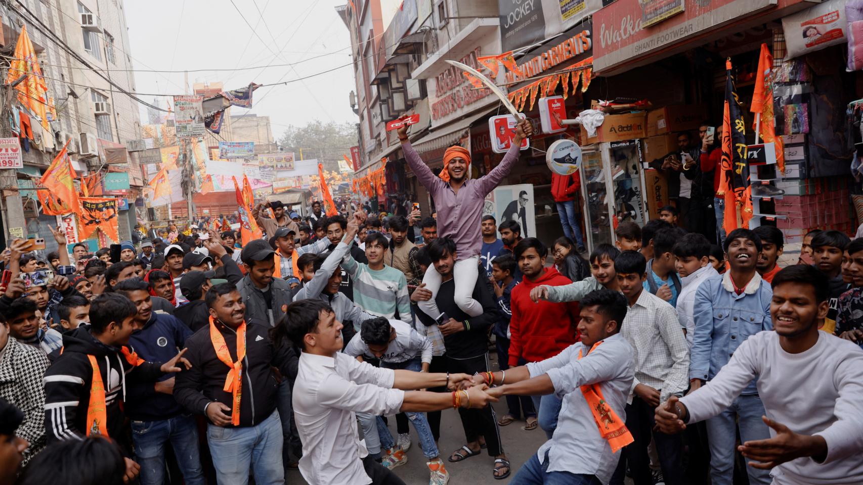 La gente celebra la inauguración del gran templo del dios hindú Ram en la ciudad norteña de Ayodhya, en una calle de Nueva Delhi, India, 22 de enero de 2024.