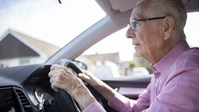 Un señor mayor conduciendo.