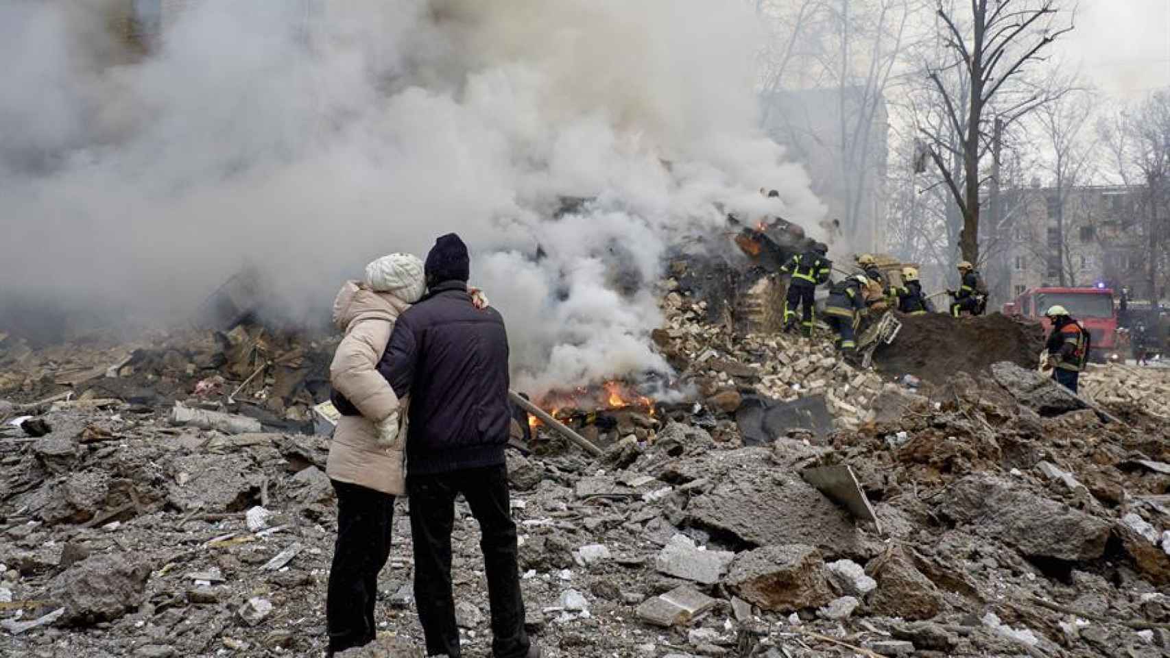 Los lugareños observan los escombros después de que un cohete impactara en un edificio residencial en Járkov, al noreste de Ucrania, el 23 de enero de 2024.