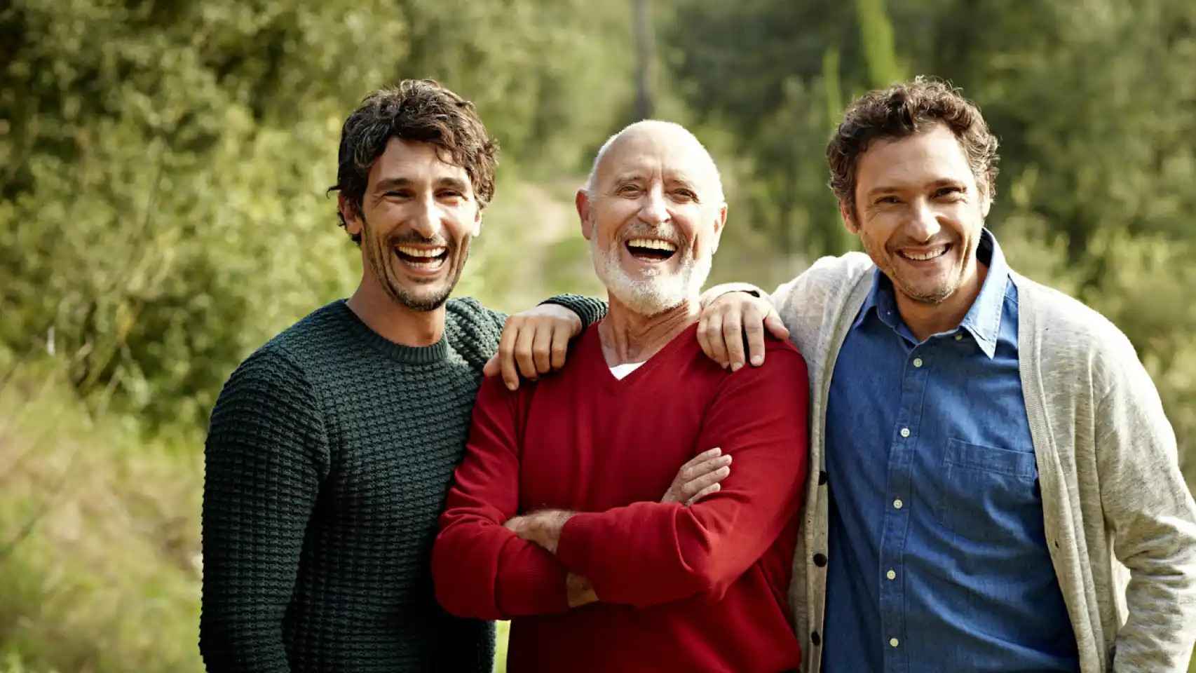 Imagen de archivo de tres hombres sonriendo.