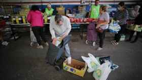 Unas personas recogen comida en un Banco de Alimentos, en Lugo.