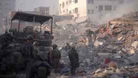 Varios soldados israelíes alrededor de los escombros de los edificios destruidos en la Franja de Gaza.
