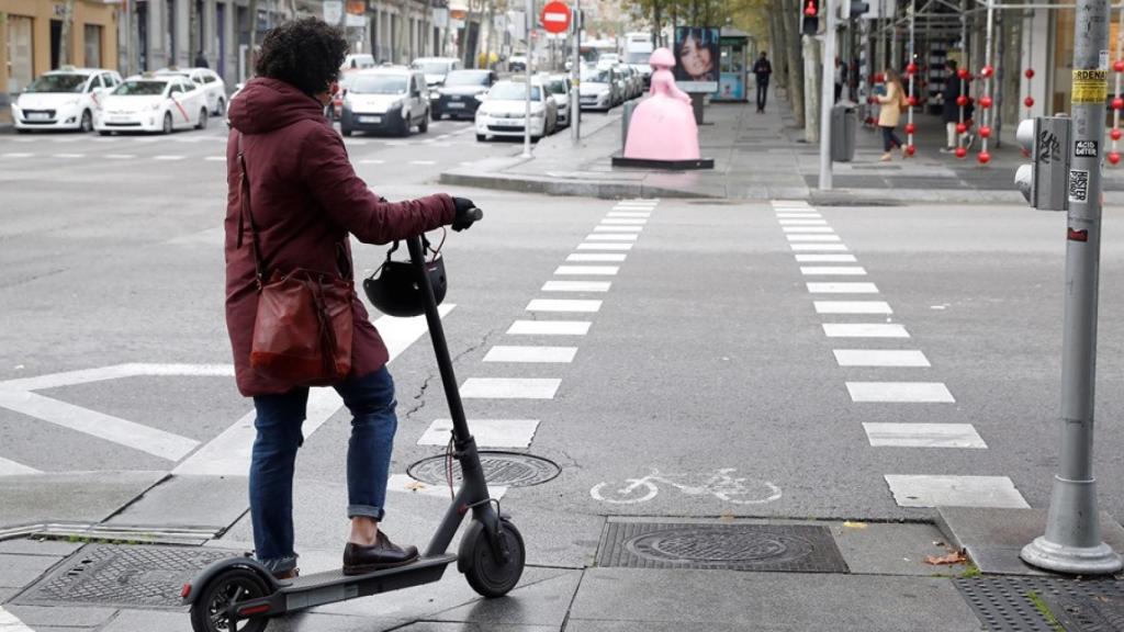 Imagen de archivo de una mujer con un patinete eléctrico.