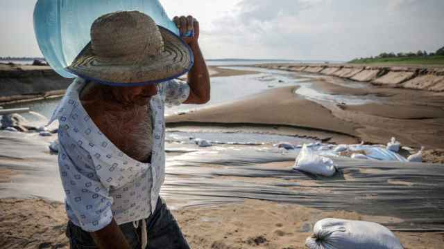Un hombre lleva una jarra de agua durante una sequía histórica en el Amazonas, 26 de octubre de 2023.