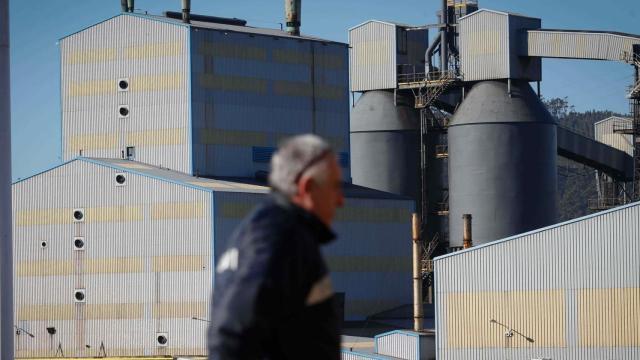 Un trabajador pasa frente a las instalaciones de Alcoa San Cibrao.