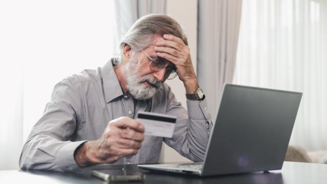 Un hombre utiliza su tarjeta bancaria para hacer una compra por Internet.
