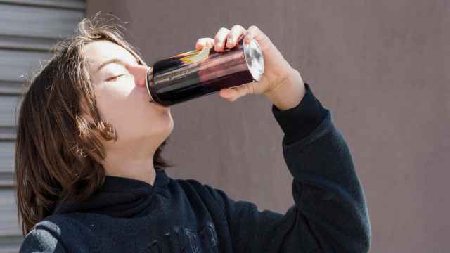 Un joven bebe una bebida energética.