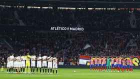 Los jugadores del Atlético de Madrid y del Sevilla guardan un minuto de silencio.