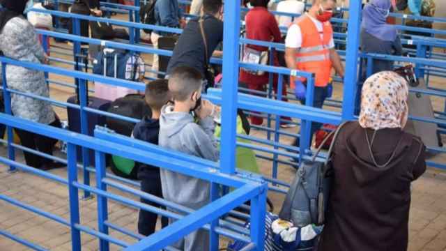 Mujeres marroquíes, algunas acompañadas por sus hijos, esperan a cruzar la frontera para trabajar en España.