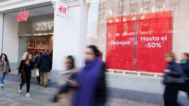 Varias personas caminan frente a una tienda de H&M