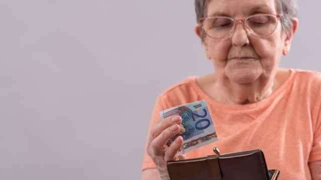 Imagen de archivo de una mujer sacando un billete de veinte euros de su monedero.