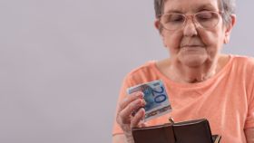 Imagen de archivo de una mujer sacando un billete de veinte euros de su monedero.
