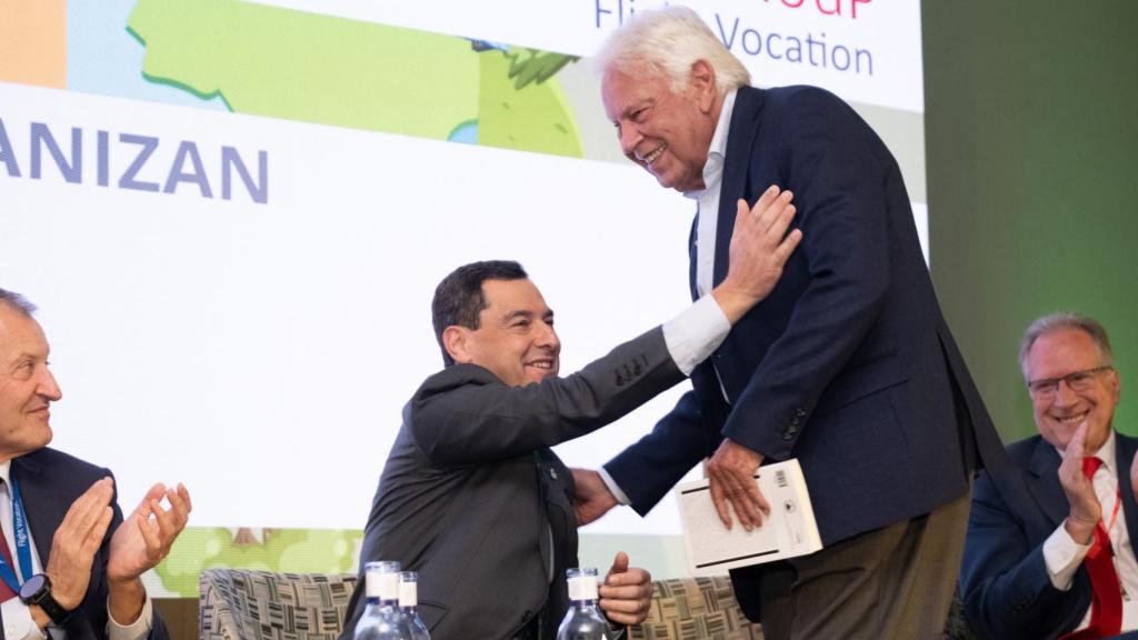 El presidente de la Junta de Andalucía, Juanma Moreno, saluda al expresidente del Gobierno Felipe González (d) tras su intervención de este lunes en Sevilla.