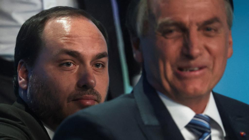 Jair Bolsonaro y su hijo Carlos asisten a un debate presidencial, en 2022 en Río de Janeiro.