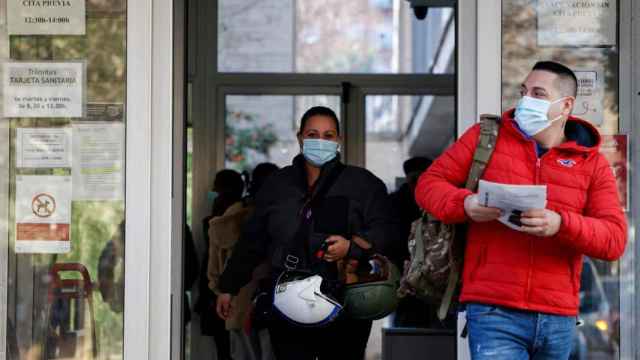 Dos personas salen de un centro de salud valenciano protegidos con una mascarilla, en una imagen de archivo. Efe / Biel Aliño
