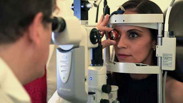 Un oftalmólogo realizando una revisión.