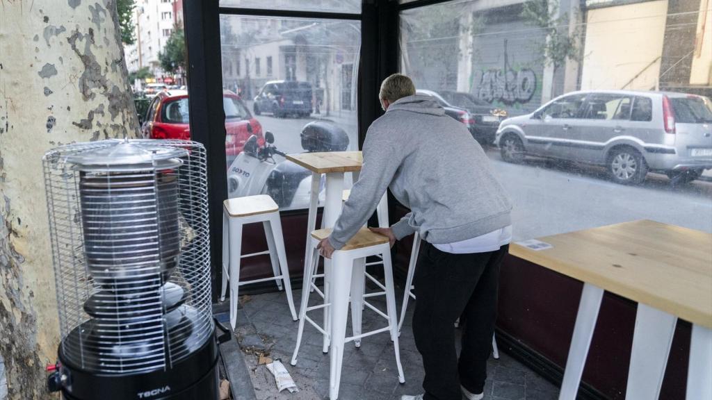 Un hombre recoge una terraza en la calle de Gaztambide de Madrid.