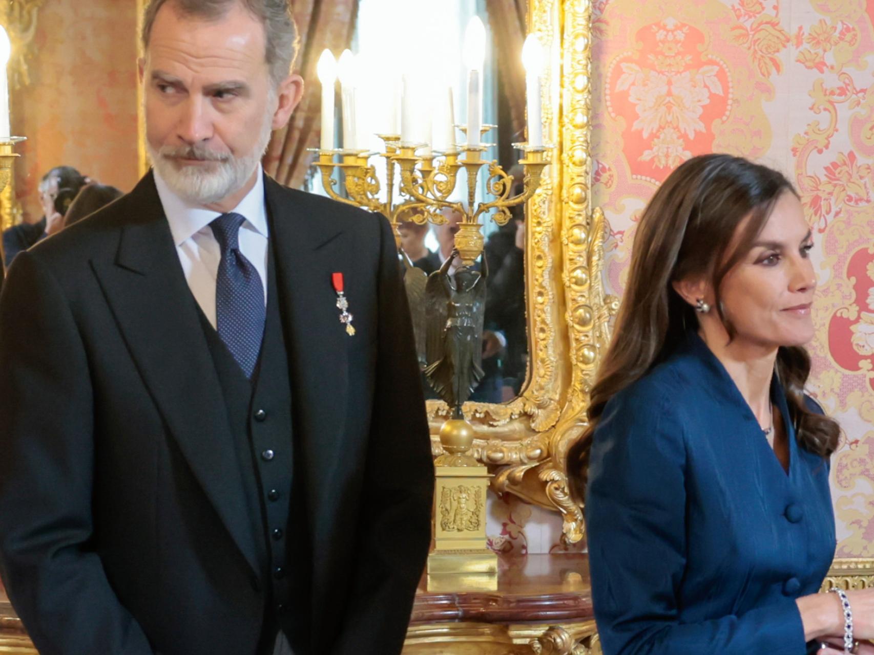 La reina Letizia intentando abrochar su pulsera.