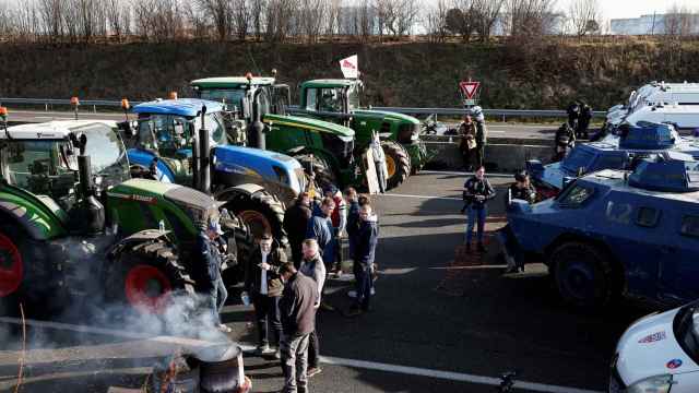 Vehículos blindados de la Gendarmería francesa frente a los tractore de los protestantes en la autopista A1 , cerca de París (Francia), el 31 de enero de 2024.