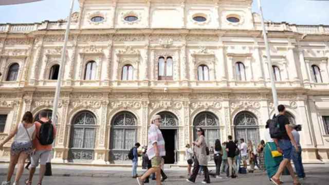 Sevillanos pasean ante el Ayuntamiento.