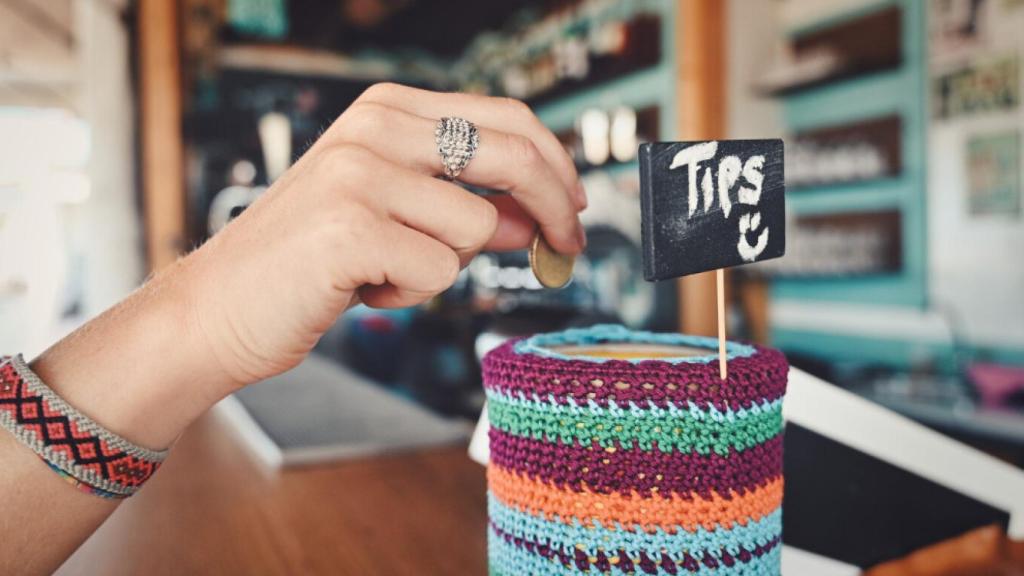 Imagen de archivo de una persona dejando propina en una cafetería.