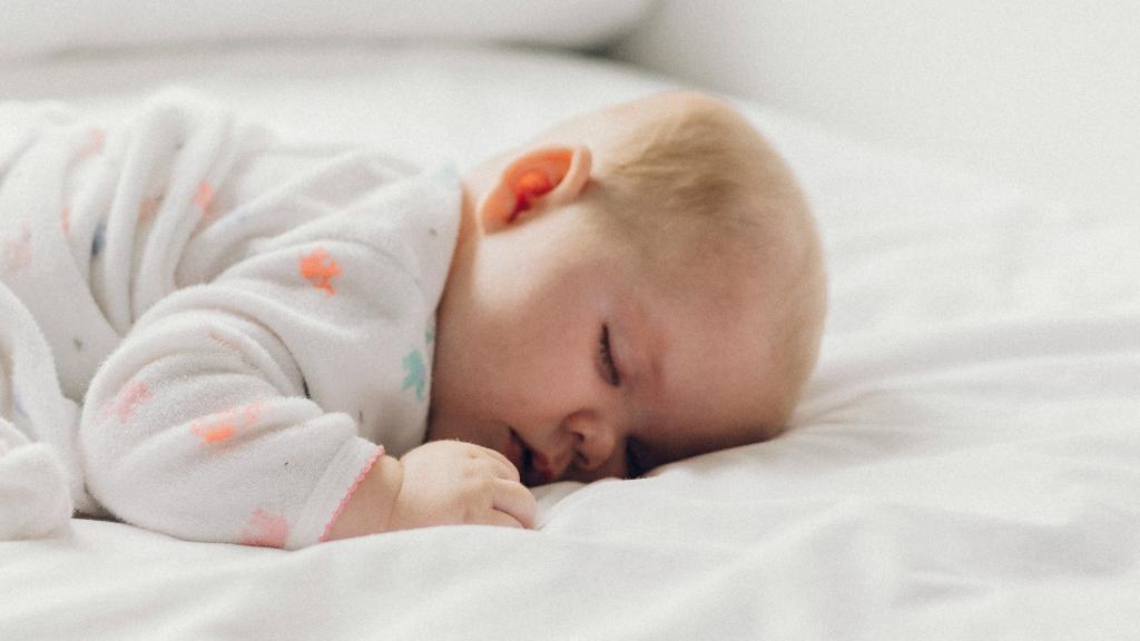 Imagen de un bebé sobre una cama